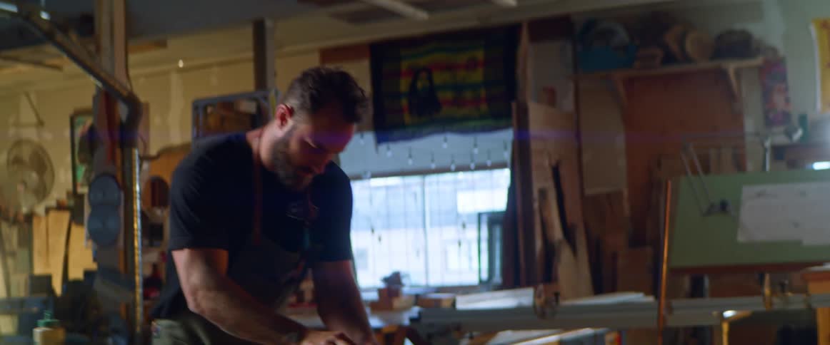 A man planning some wood in a wood shop