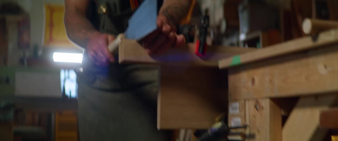 A man cutting wood in his garage