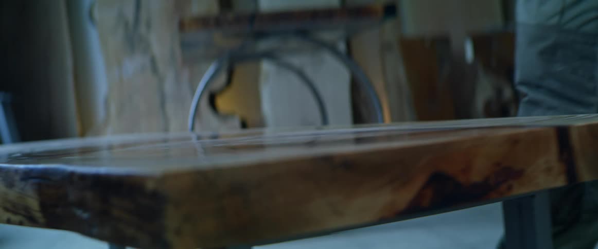 Man wipes the top of a shiny bench with his hand