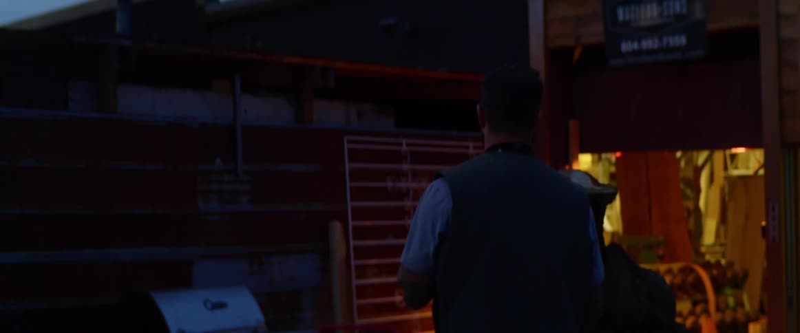 Person walks past a van with commercial logo carrying items into open shop