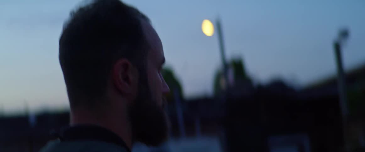A man is walking outdoors at night