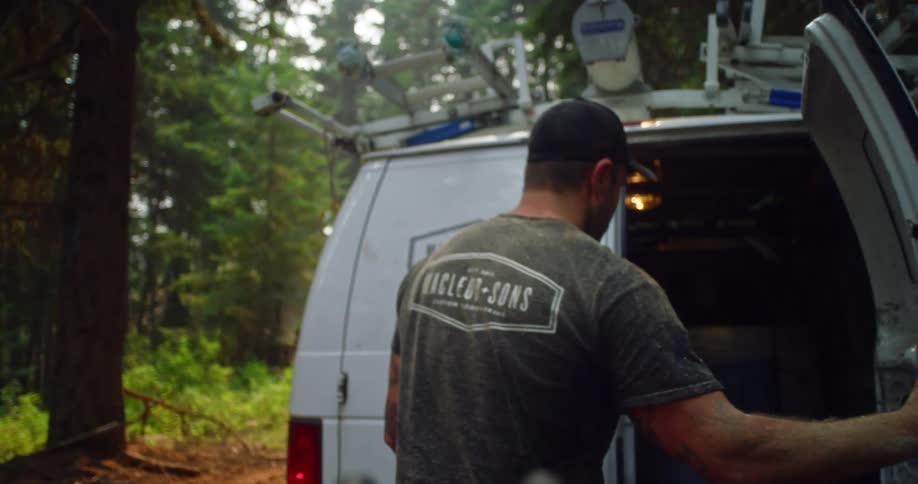 An employee opening the back door of a van in the woods