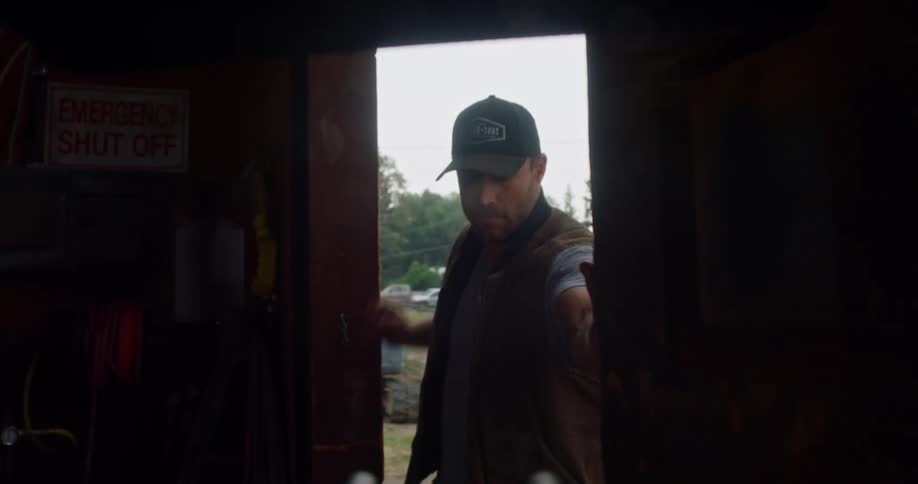 A man in a rural area walks into a shed