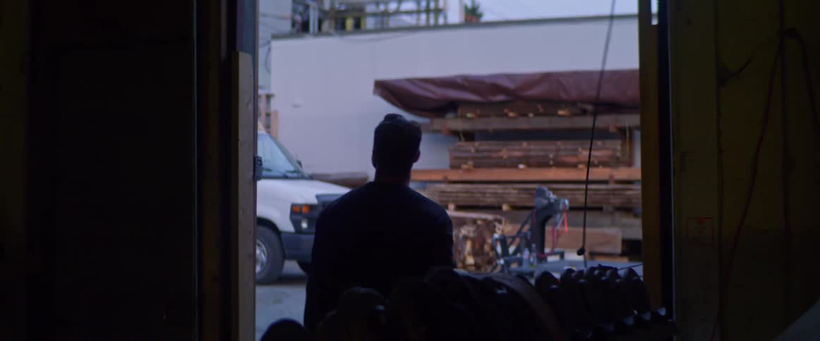 A man in a garage lifts open the garage door