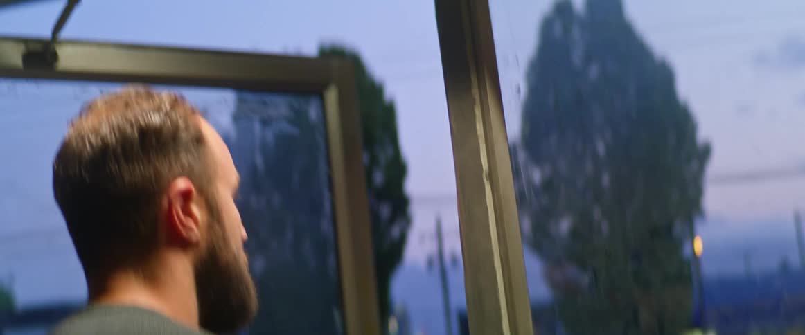 Man walks out of gas station at dusk