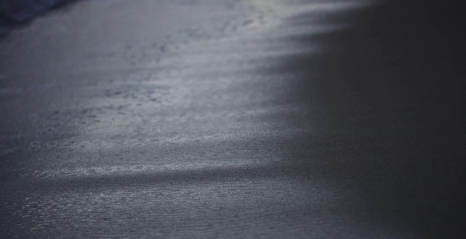 Close up of the tide coming in on sandy beach