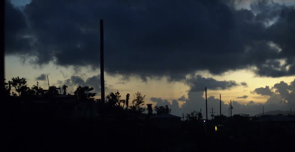 Neighborhood silhouetted against cloudy sky at dusk