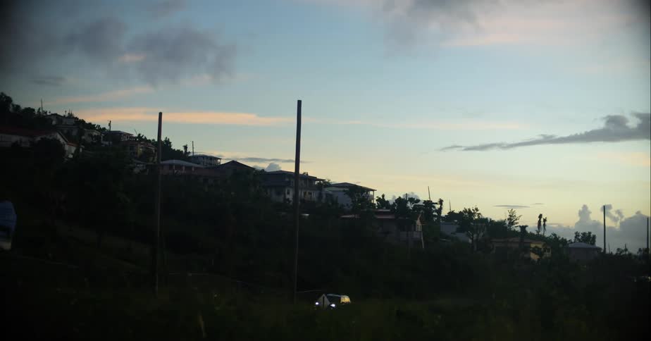 A small town on the side of a large hill in the evening