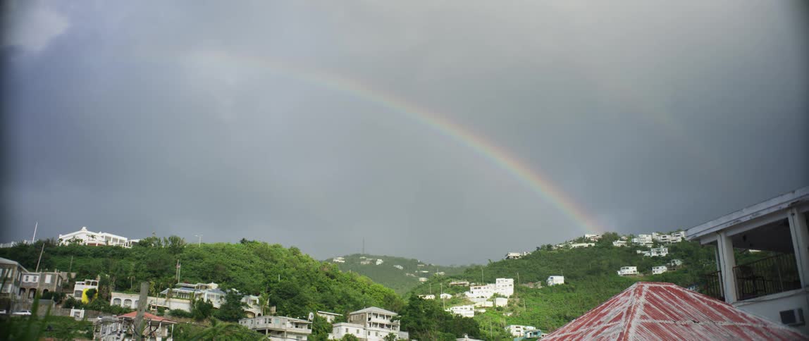A rainbow runs over the town on the hills
