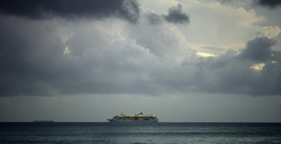 Clouds float above a ship sailing on ocean water in the daytime