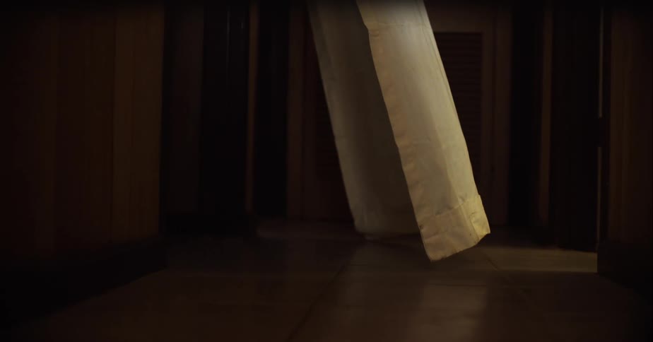 Wind blowing through a long white curtain inside a home