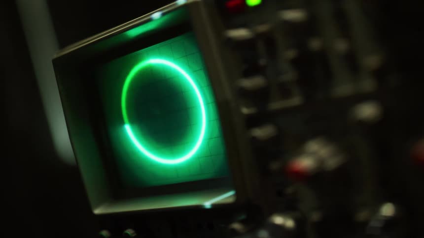 A green circle changes shape and sizes on a small oscilloscope screen