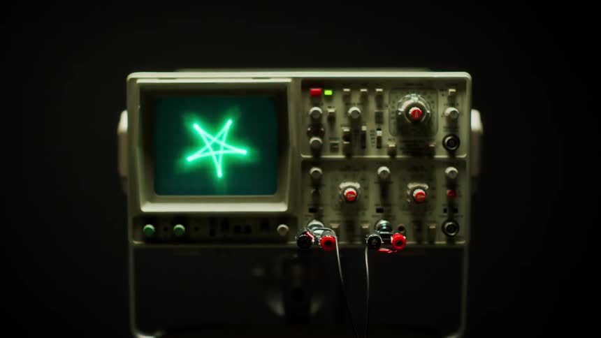 Green lights flashing on a display monitor next to buttons and knobs of an oscilloscope