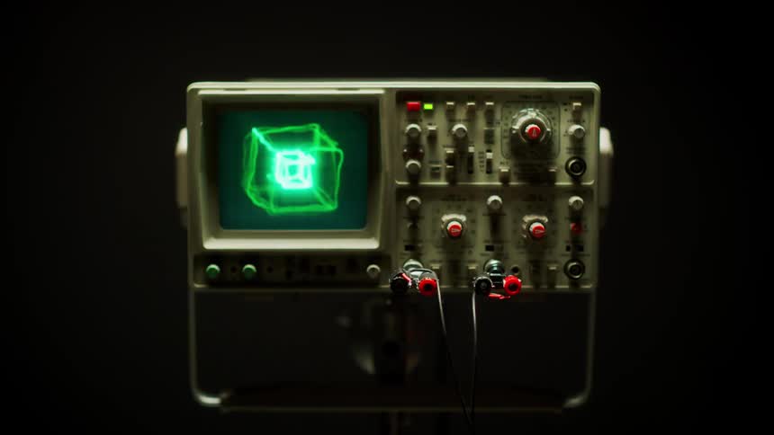 An oscilloscope displaying many different patterns on its screen sits in a dark room