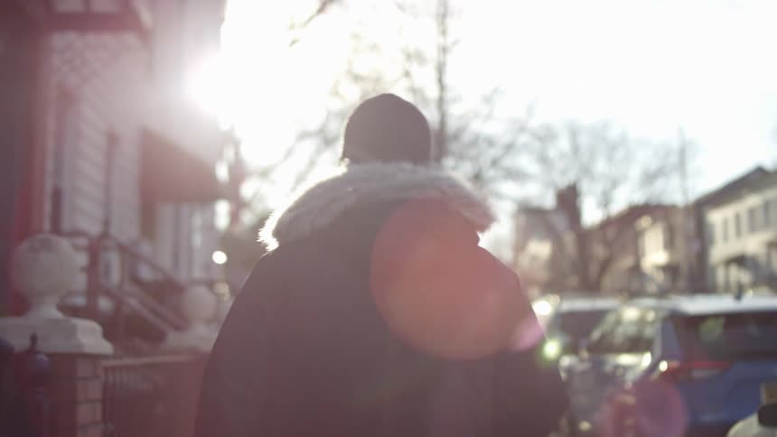A man is walking outdoors in a neighborhood