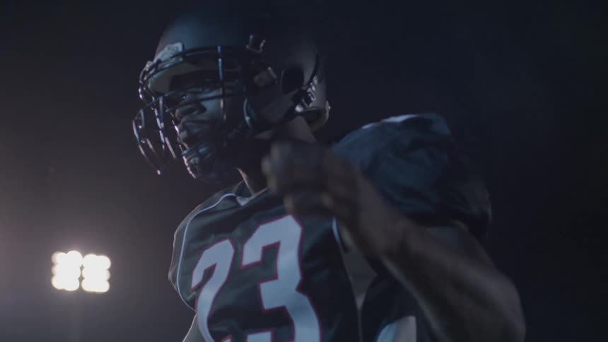 A football player hitting the helmet on his head