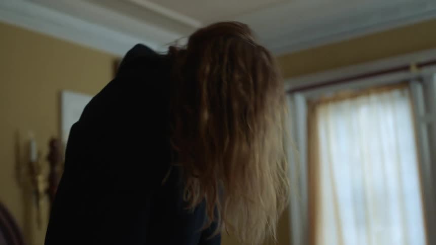 A woman standing up on a bed