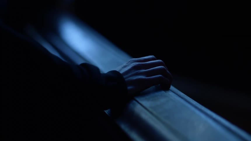 A person tapping their fingers on a banister