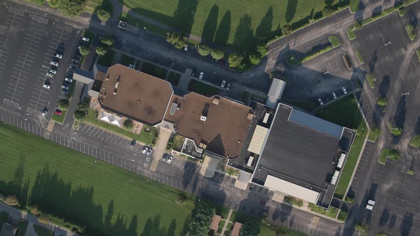 The rooftop of a building surrounded by nicely landscaped grounds