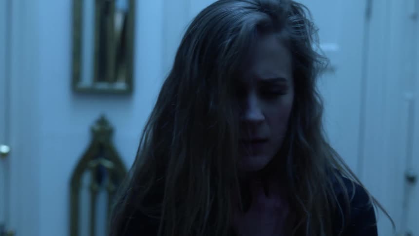 A woman is breathing heavy and holding her chest