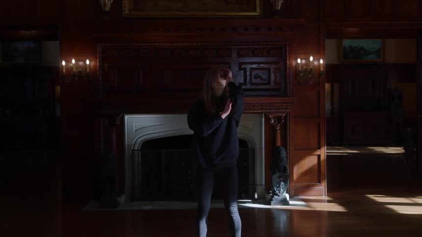 A woman is doing yoga in the large room