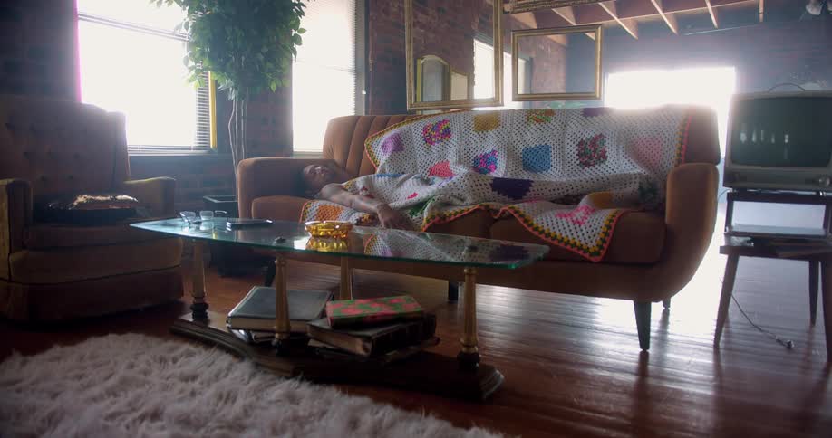 A man sleeps on the couch during the day time