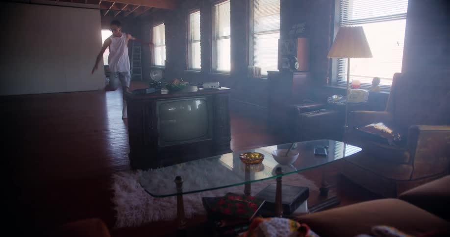 Man wearing socks dances on wooden floor in empty area of home