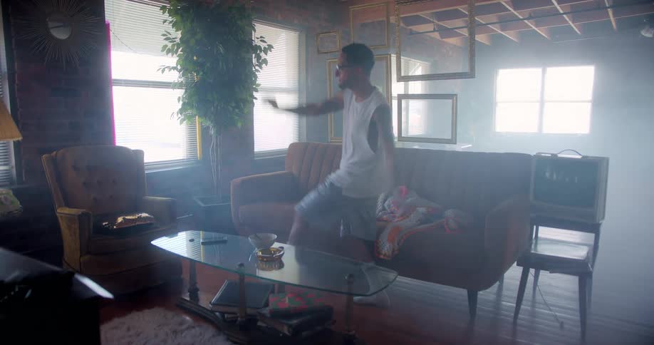 A man dances around in his living room