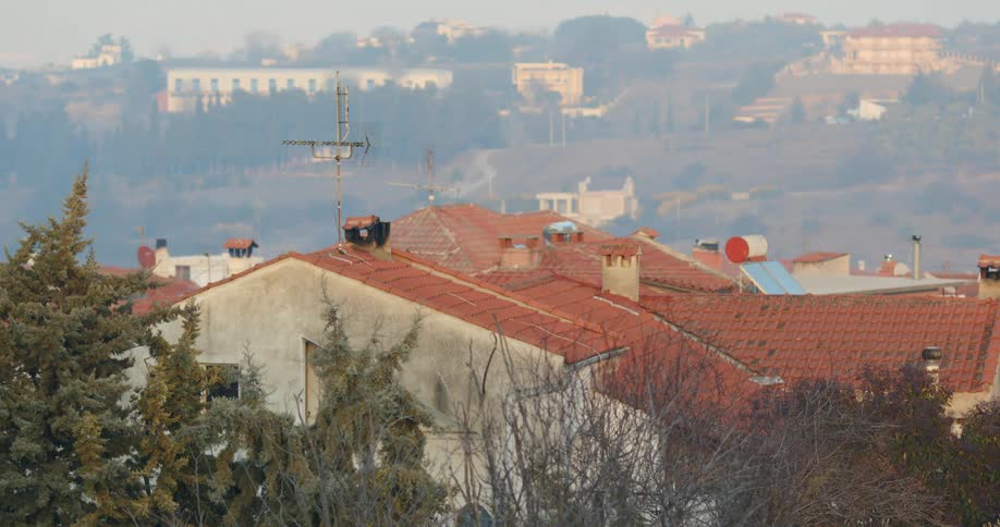 Fog covers homes and other buildings occupying valley and hills