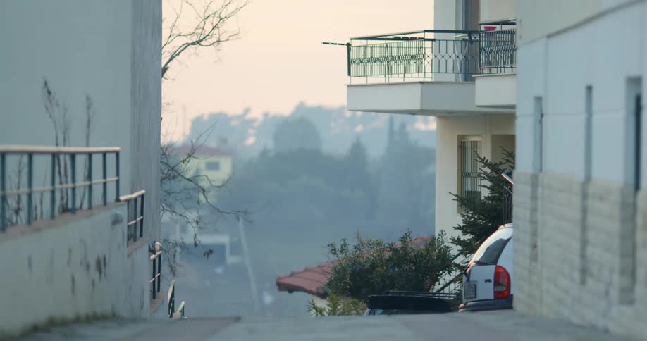 A narrow road through a neighborhood on a hillside