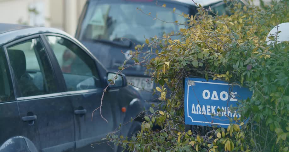 Cars parked on a road near a sign