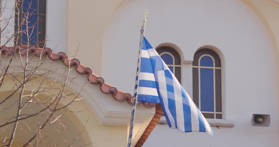 Greek flag flying outside of white building
