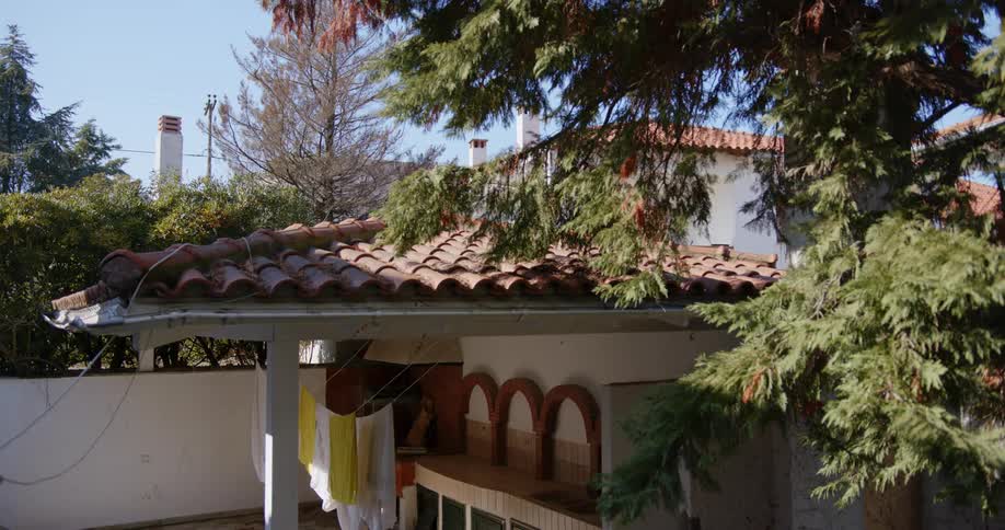 Clothes hang dry on a line on a patio under a stucco roof