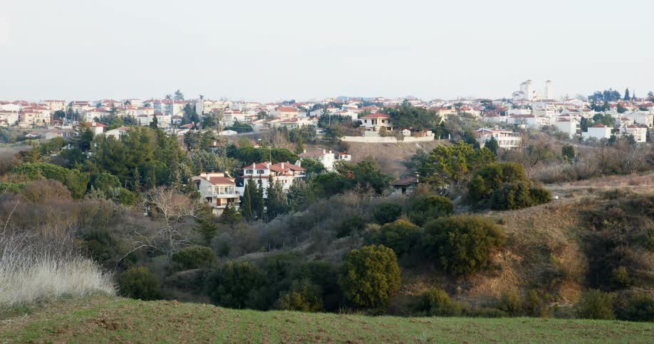 A landscape view of a field in front of a neighborhood