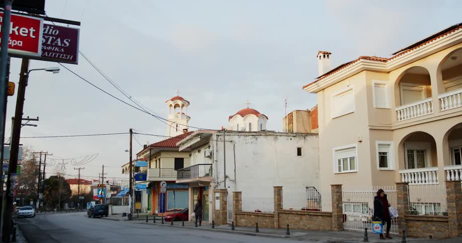 A small downtown area in a town with people and traffic
