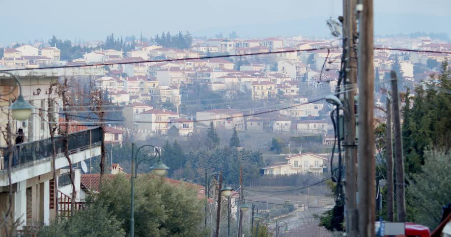 White houses with brown rooftops on hillside