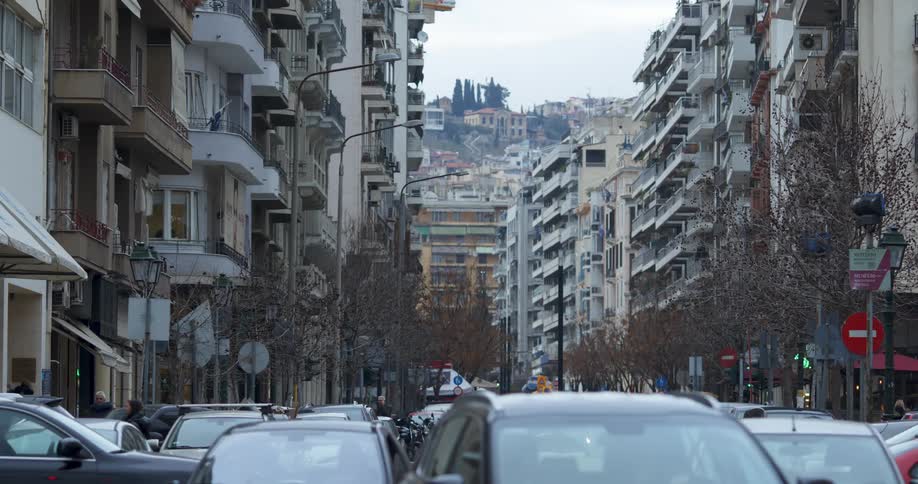 Traffic along a busy street in a metropolis during the day