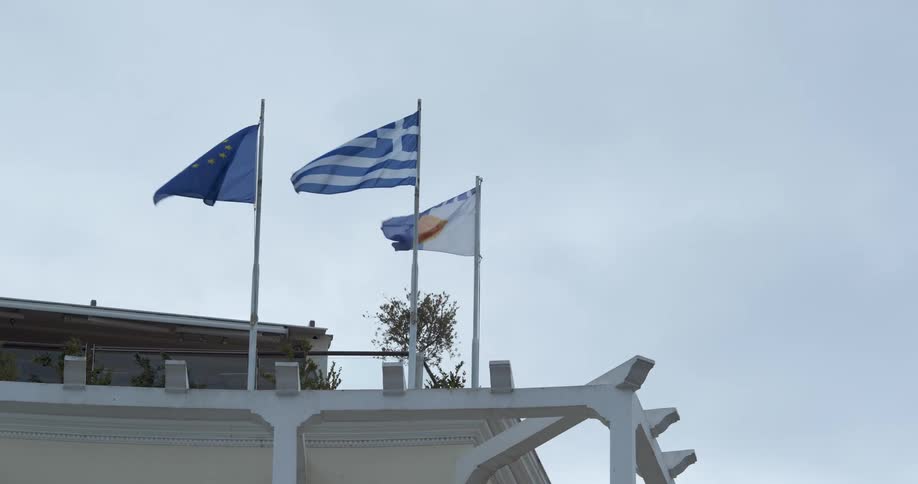 Flags blowing in the wind in front of a building