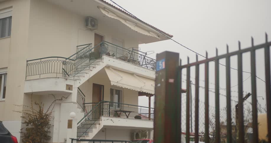 A young woman leaves her apartment and heads to the stairs