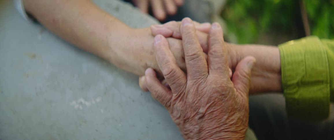 Two people holding hands sitting by a table