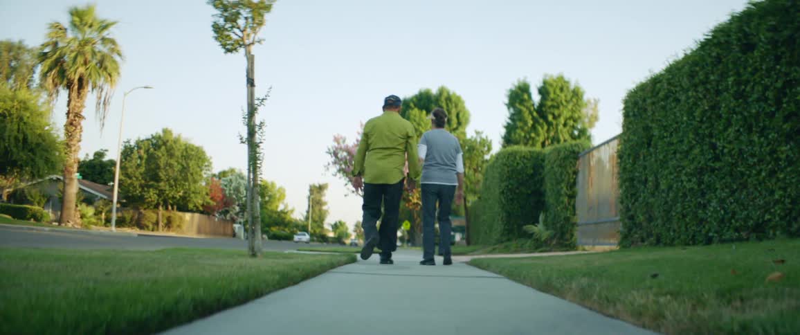 Man and woman are holding hands and walking outdoors in spring