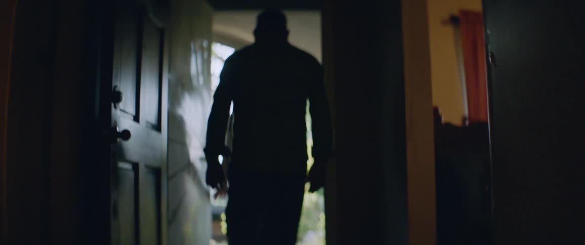 A man and woman walking out the front door of a house