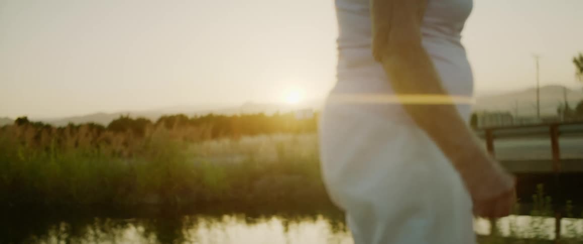 Elderly woman is walking in a rural area at dusk