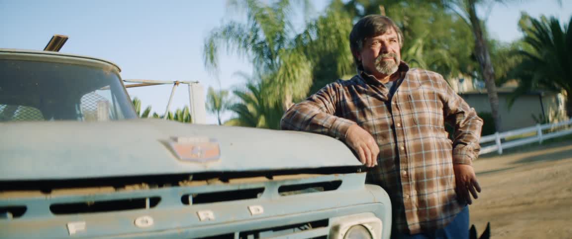 Man leaning on vintage ford pickup truck