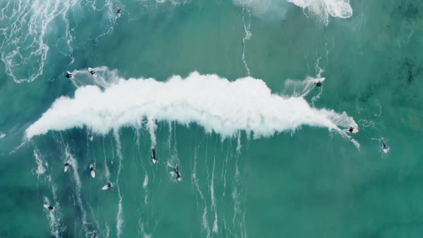 Aerial view of multiple surfboarders in ocean