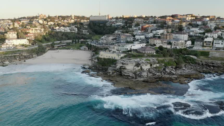 An aerial view of a neighborhood on the shore and people playing in the water
