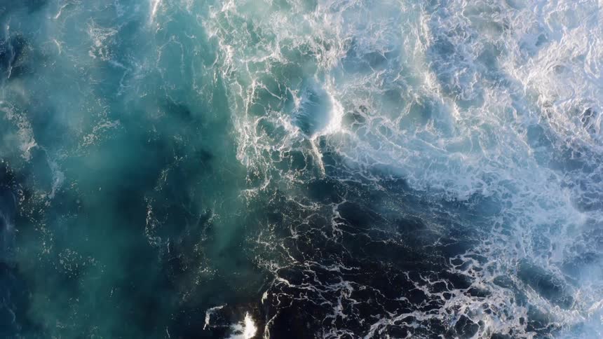 Waves crash together on the ocean ona sunny day