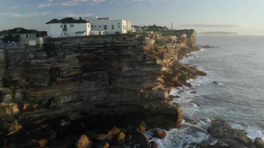 A view of houses atop a cliff on the coast