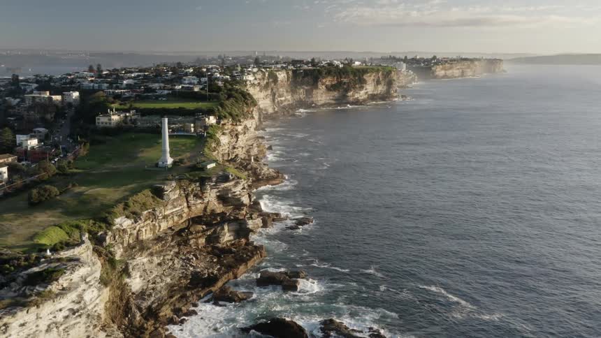 Aerial view of a cliff town stretching along the shoreline