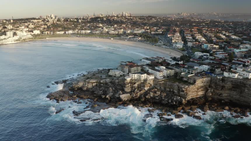 A coastal city with buildings and trees with the sky and clouds in the background